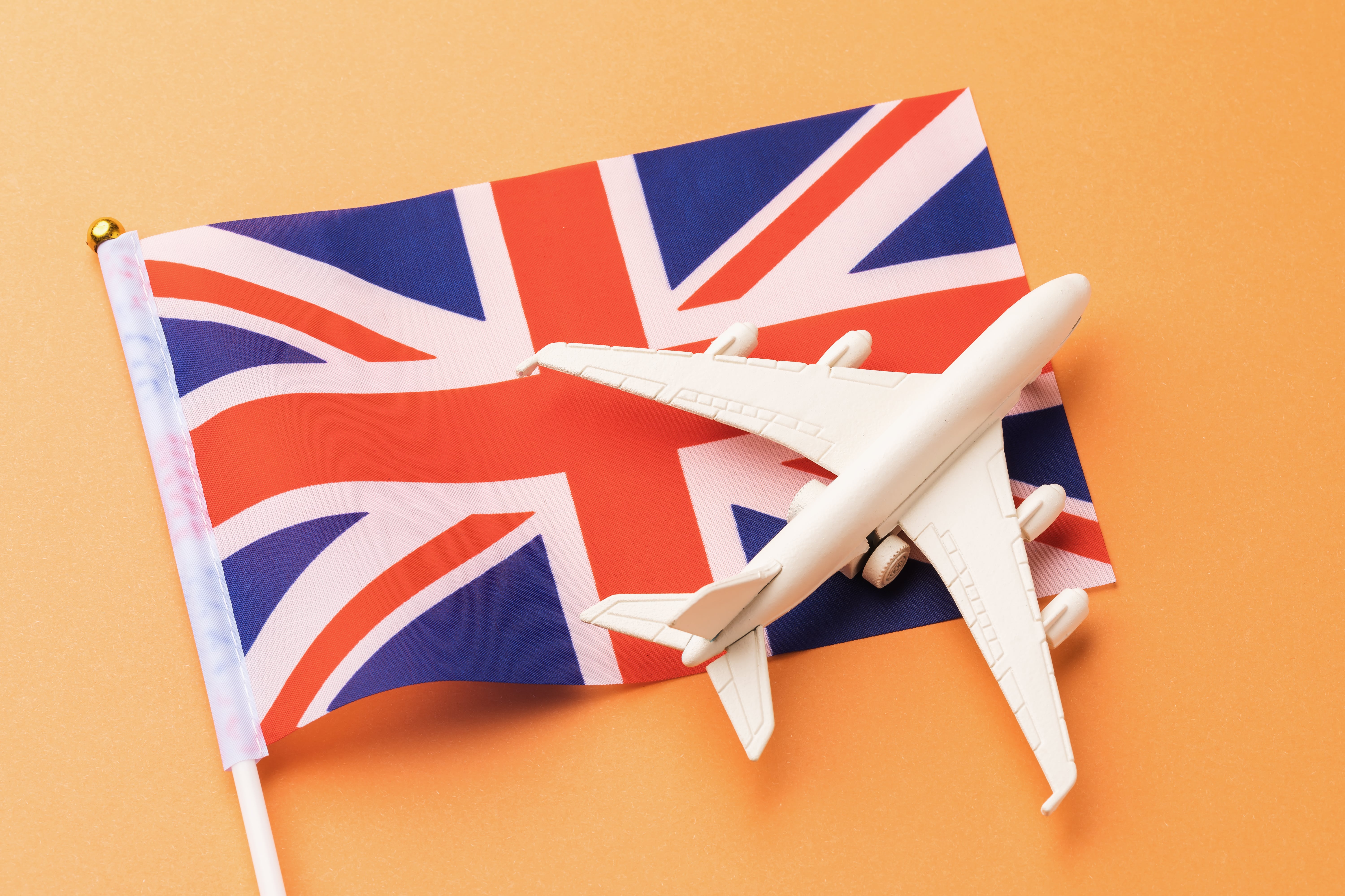 great-britain-flag-toy-plane-orange-background-concept-flying-united-kingdom